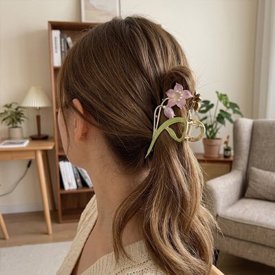 Pince à cheveux fleur mauve femme fait une queue de cheval